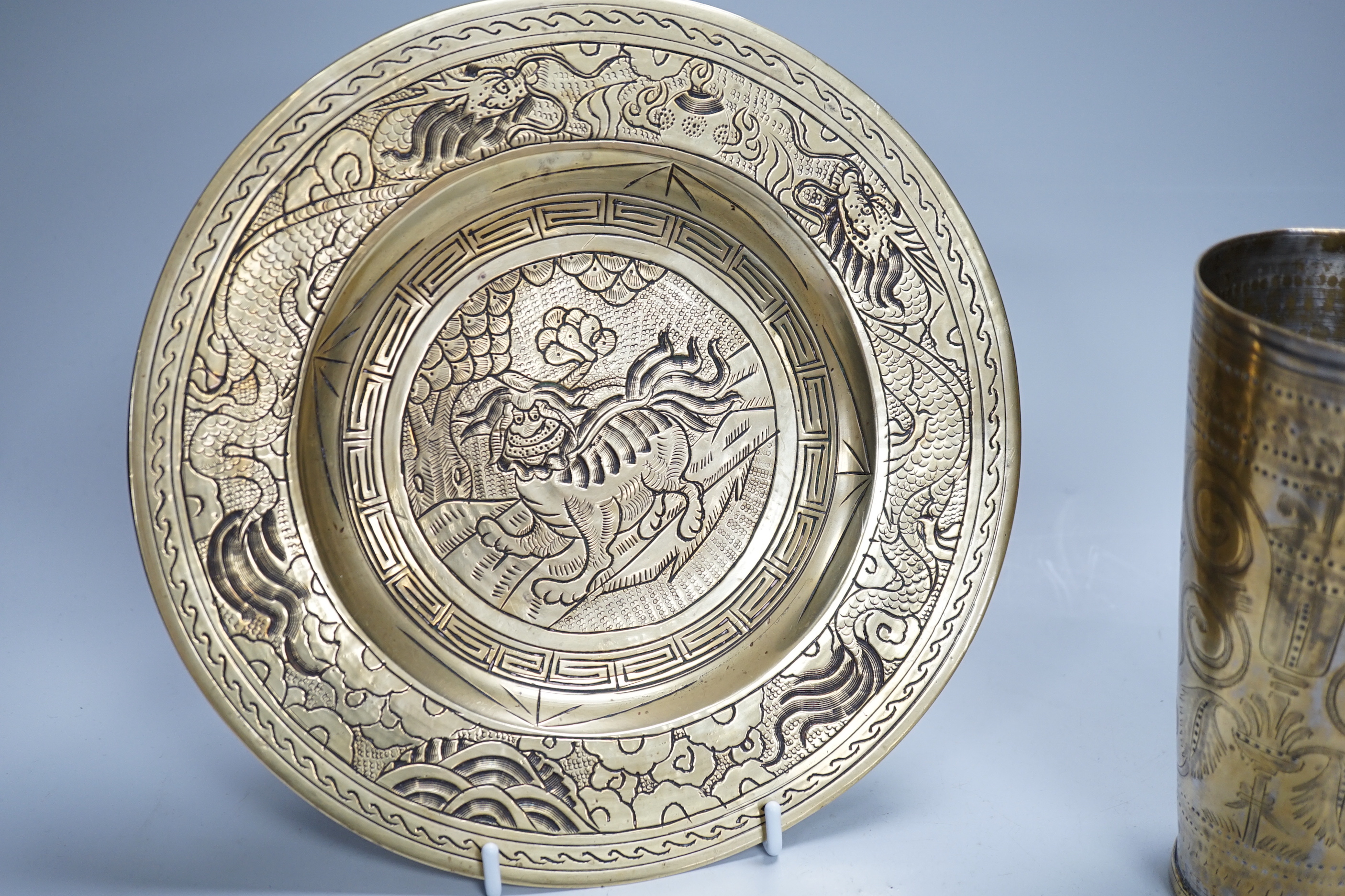 A Chinese engraved brass plate, large engraved beaker, koi fish and a dragon, the largest 24cm in diameter